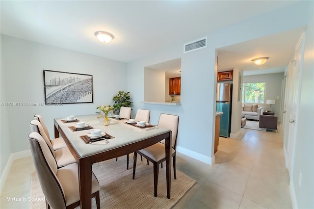 dining room with visible vents, baseboards, and light tile patterned flooring