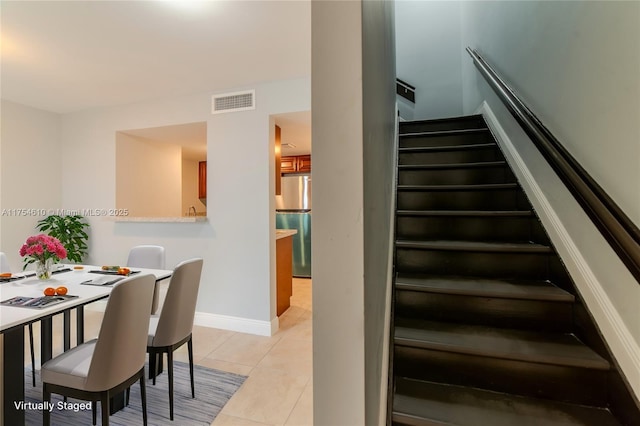 stairs featuring visible vents, baseboards, and tile patterned floors