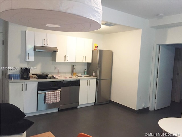 kitchen with white cabinets, under cabinet range hood, stainless steel appliances, and light countertops