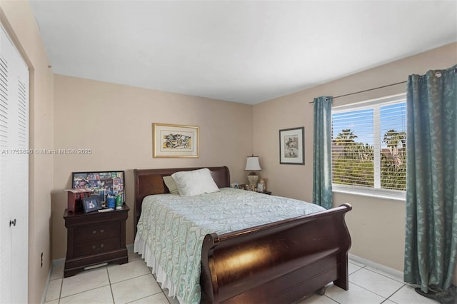 bedroom with light tile patterned flooring and baseboards