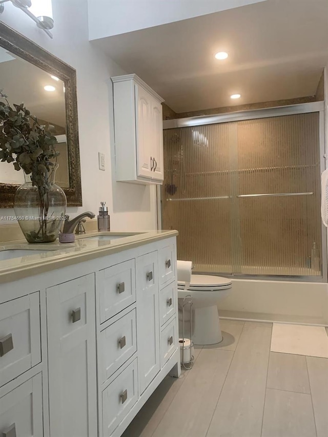 full bath with tile patterned flooring, toilet, recessed lighting, vanity, and combined bath / shower with glass door