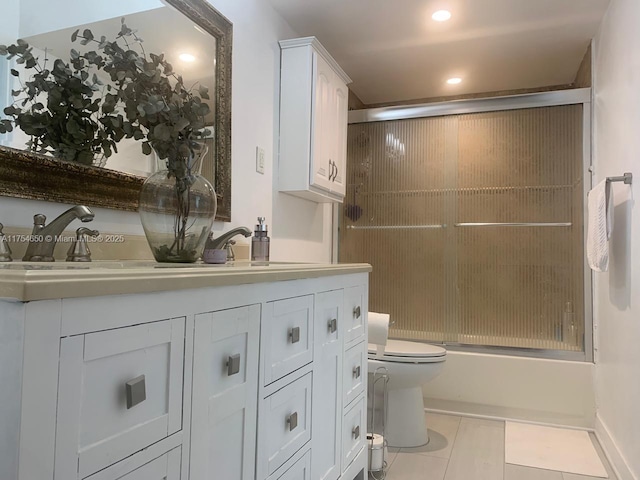 bathroom featuring double vanity, toilet, tile patterned floors, combined bath / shower with glass door, and a sink