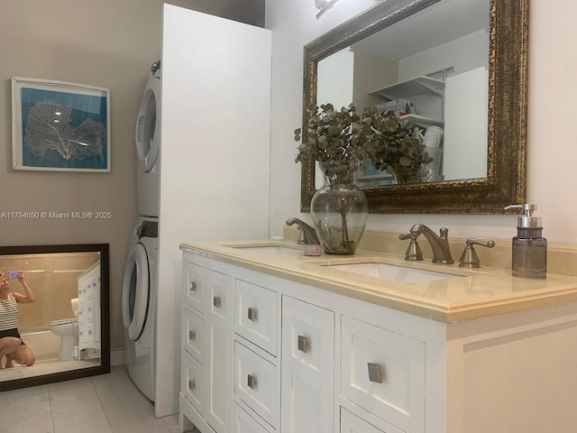 bathroom featuring a sink, tile patterned flooring, double vanity, and stacked washer / drying machine