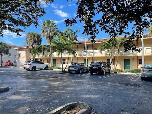 view of building exterior featuring uncovered parking and a residential view