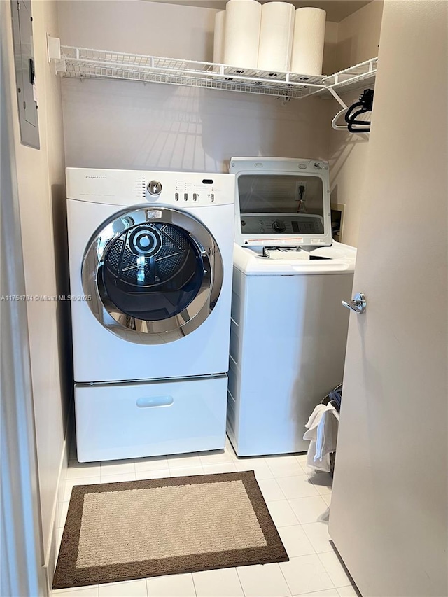 washroom with electric panel, tile patterned floors, laundry area, and washer and clothes dryer