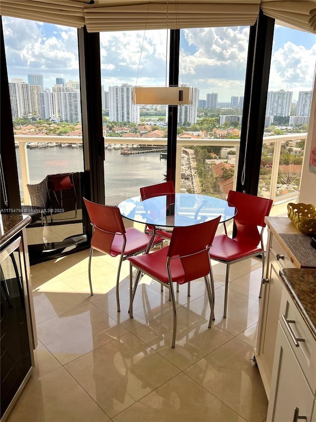 sunroom featuring a view of city, a water view, and wine cooler