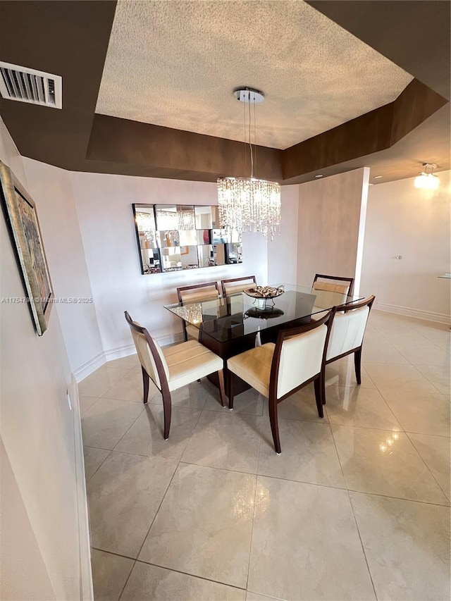 dining room with light tile patterned floors, visible vents, a chandelier, and a textured ceiling