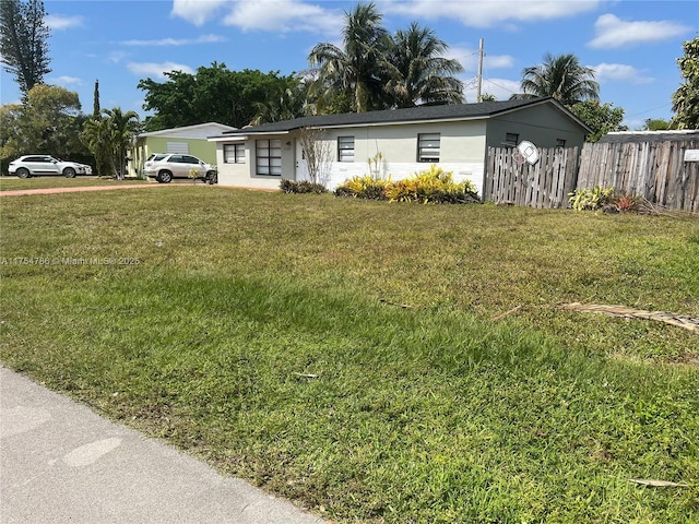 single story home featuring a front yard, fence, and stucco siding