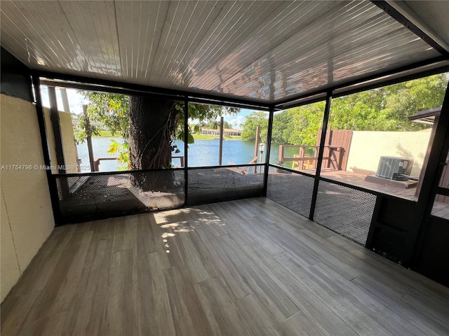 unfurnished sunroom featuring a water view