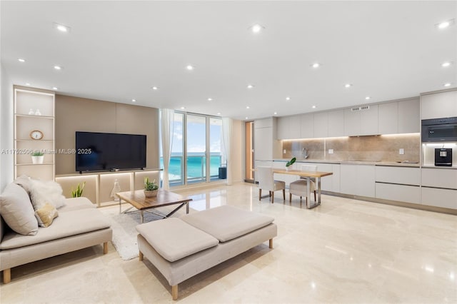 living room featuring a wall of windows and recessed lighting