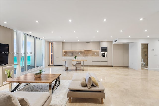 living room with baseboards, expansive windows, visible vents, and recessed lighting