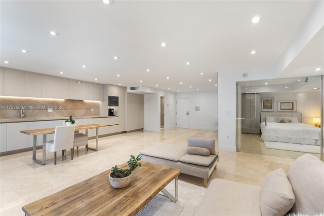 living room with baseboards, visible vents, and recessed lighting