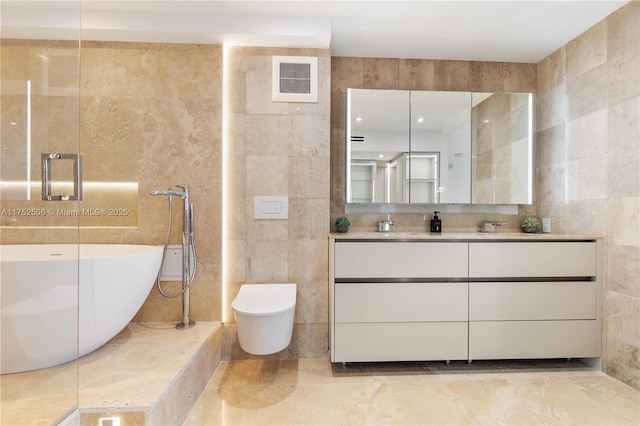 full bath with toilet, a freestanding tub, tile walls, and vanity