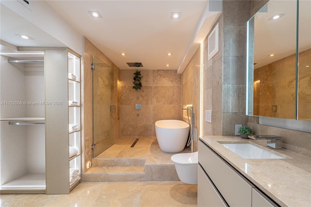 full bath featuring a freestanding tub, recessed lighting, tile walls, vanity, and a stall shower