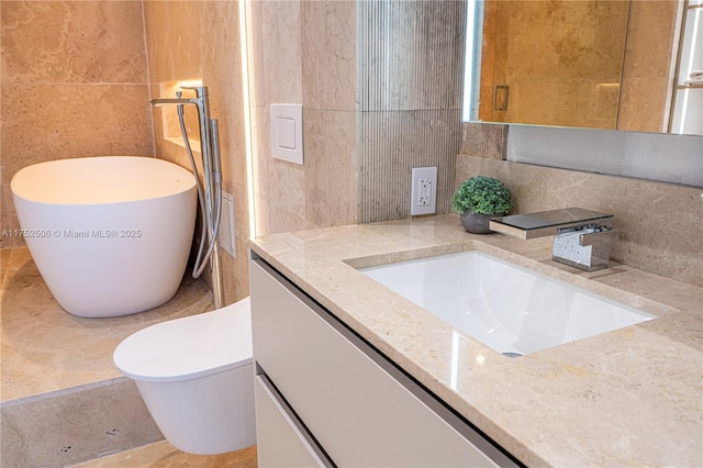 bathroom featuring tasteful backsplash, a freestanding tub, vanity, and tile walls