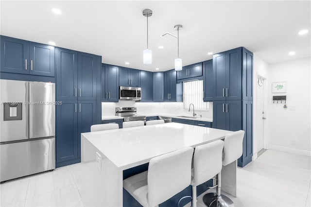 kitchen featuring blue cabinets, appliances with stainless steel finishes, light countertops, and a sink