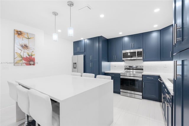 kitchen featuring tasteful backsplash, a kitchen island, appliances with stainless steel finishes, light countertops, and blue cabinetry