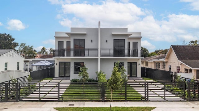 view of front of property with a fenced front yard, a gate, and stucco siding