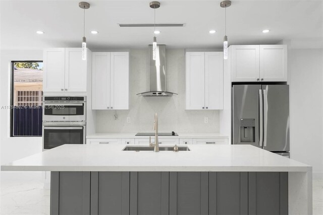 3430 SW 2nd St, Miami, FL 33135 - kitchen featuring appliances with stainless steel finishes, a center island with sink, backsplash, and wall chimney exhaust hood
