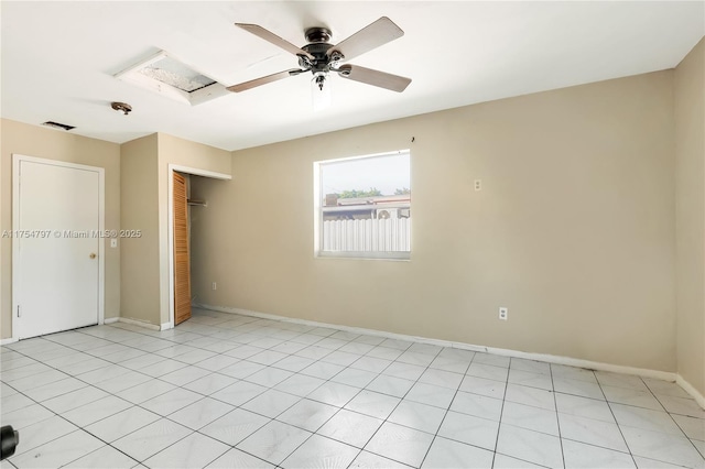 unfurnished bedroom featuring attic access, visible vents, baseboards, a ceiling fan, and a closet