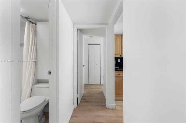 corridor with light wood-style floors and visible vents