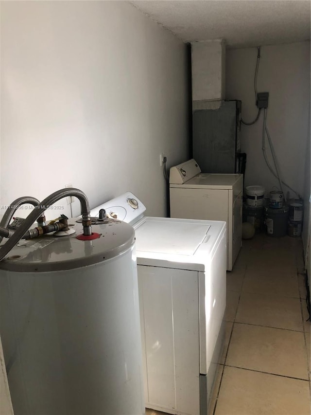 laundry area with light tile patterned floors, water heater, and separate washer and dryer