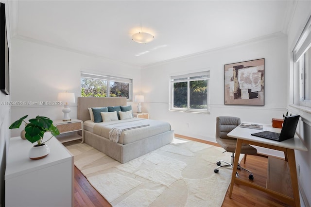 bedroom featuring ornamental molding and wood finished floors