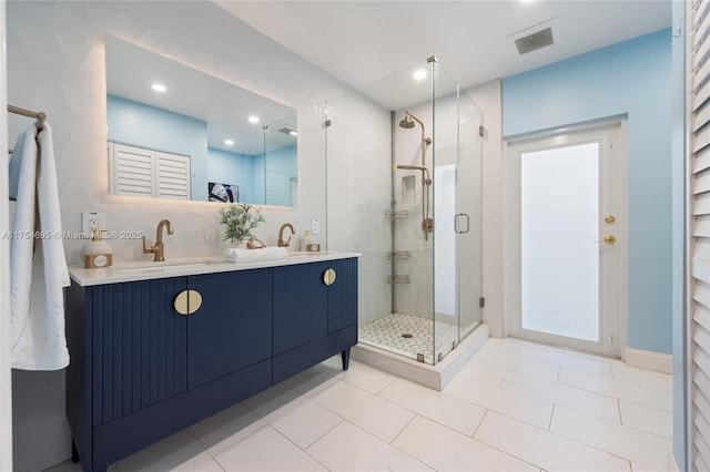 full bathroom featuring double vanity, a sink, visible vents, and a shower stall