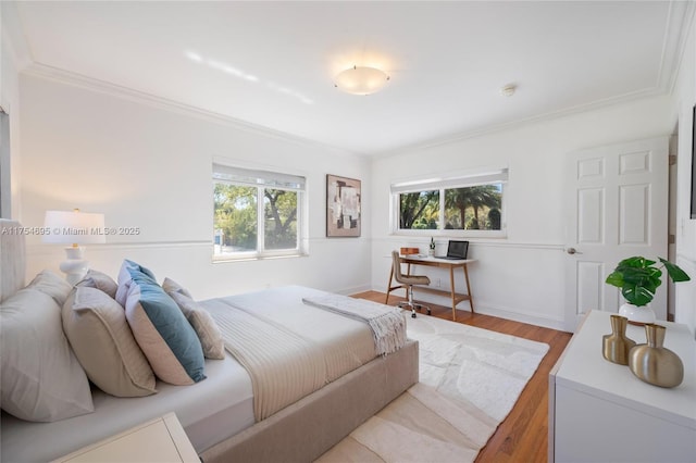 bedroom with ornamental molding, multiple windows, and wood finished floors