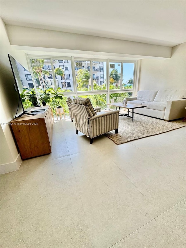 living room featuring baseboards and concrete flooring