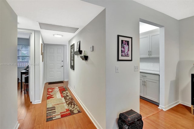 hallway with light wood-style flooring and baseboards