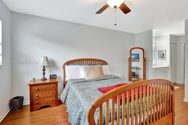 bedroom with a textured ceiling, wood finished floors, a ceiling fan, and baseboards