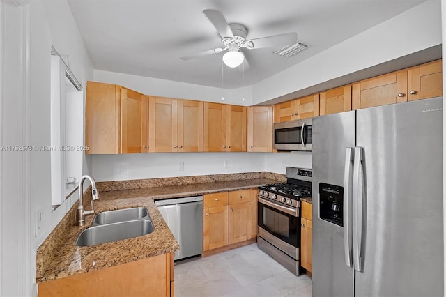 kitchen featuring visible vents, a ceiling fan, appliances with stainless steel finishes, light brown cabinetry, and a sink