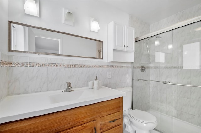 full bath featuring toilet, a stall shower, tile walls, and vanity