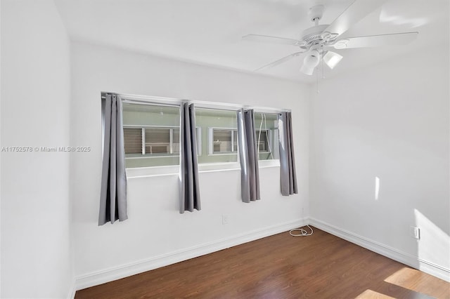 unfurnished room featuring ceiling fan, baseboards, and dark wood finished floors