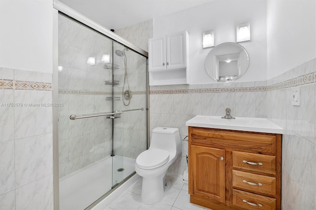 bathroom featuring tile walls, a shower stall, toilet, and vanity