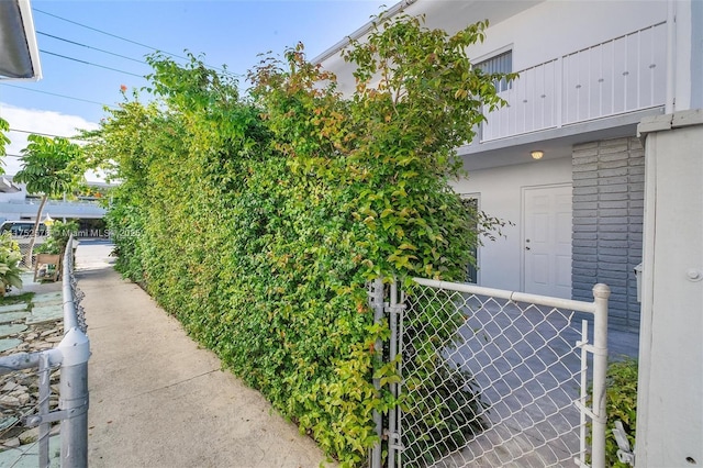 exterior space with a gate, fence, and stucco siding