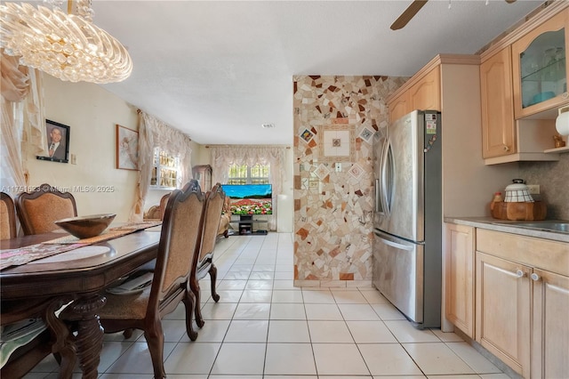 dining room featuring light tile patterned flooring and ceiling fan with notable chandelier