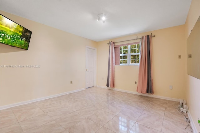 unfurnished room featuring light tile patterned floors and baseboards