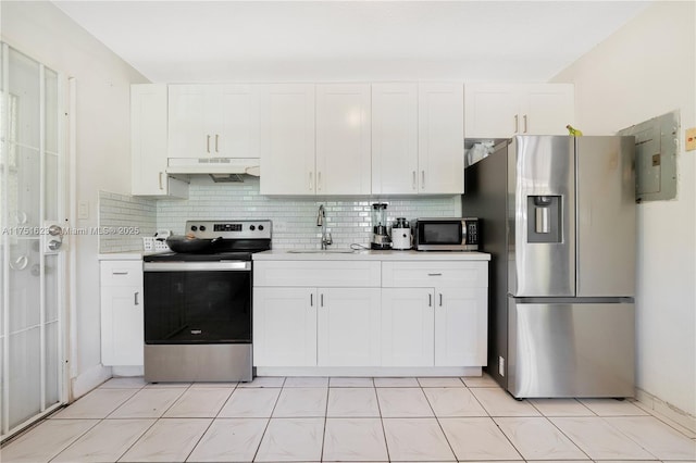 kitchen featuring under cabinet range hood, stainless steel appliances, a sink, light countertops, and backsplash