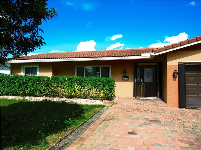 view of exterior entry featuring a tile roof