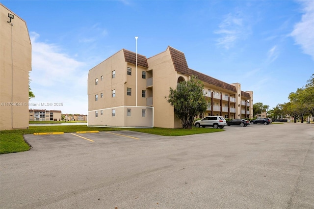 view of building exterior featuring uncovered parking