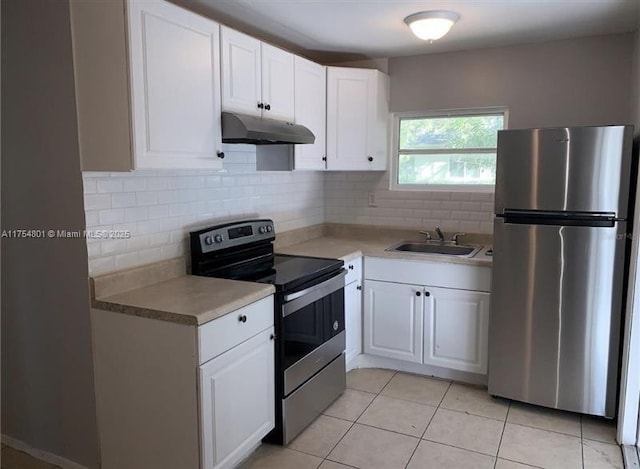 kitchen with tasteful backsplash, appliances with stainless steel finishes, white cabinetry, a sink, and under cabinet range hood