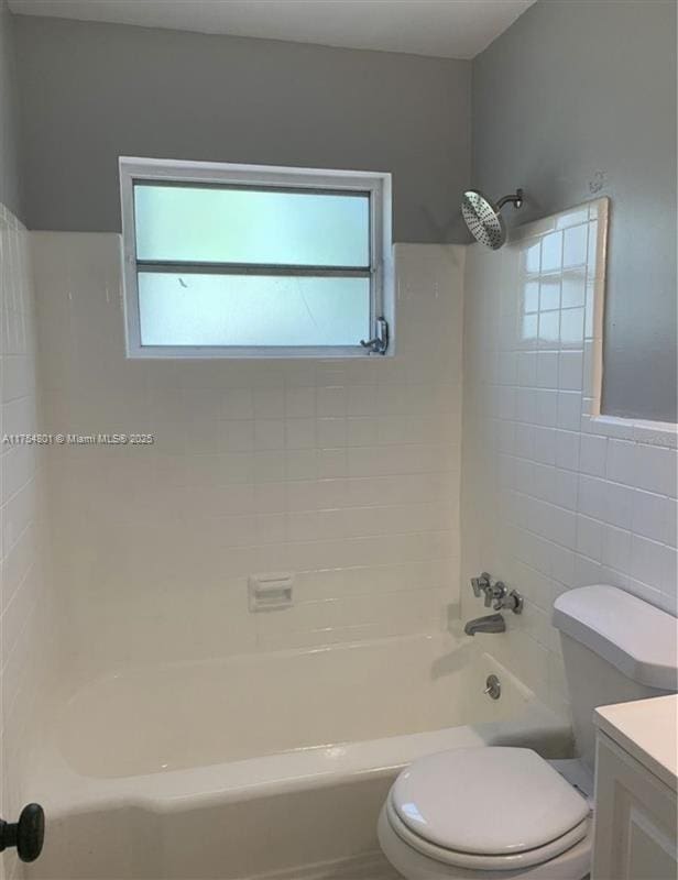 bathroom featuring toilet, tub / shower combination, tile walls, and vanity