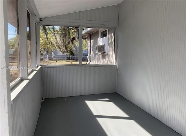 unfurnished sunroom featuring lofted ceiling and cooling unit