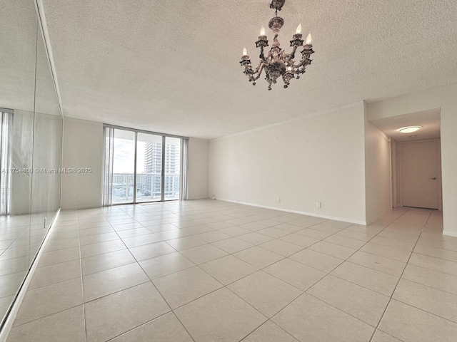 spare room featuring light tile patterned floors, a wall of windows, a textured ceiling, and an inviting chandelier