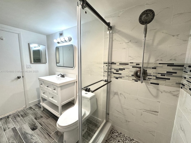 full bathroom featuring a stall shower, vanity, toilet, and wood tiled floor