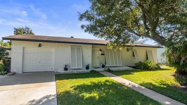 single story home featuring driveway, brick siding, a front lawn, and an attached garage