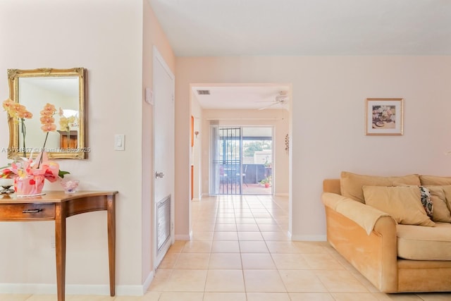 living room with light tile patterned floors, ceiling fan, visible vents, and baseboards