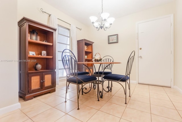 dining space featuring light tile patterned floors, baseboards, and a notable chandelier